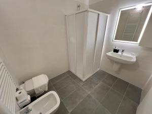 a white bathroom with a toilet and a sink at Quintarelli home Europa 1 in Negrar