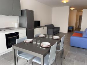 a kitchen and dining room with a table and chairs at Quintarelli home Europa 1 in Negrar