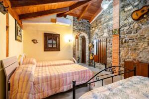 a bedroom with two beds and a stone wall at La pace dei sensi in Maida
