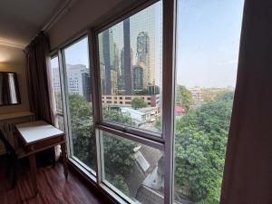 a room with a window with a view of a city at The Step Sathon in Bangkok