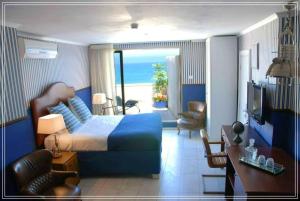 a hotel room with a bed and a view of the ocean at Bugrashov Beach 88 Hotel And Spa in Tel Aviv