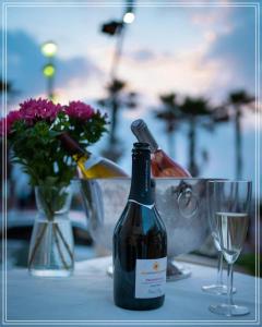 Bugrashov Beach 88 Hotel And Spa في تل أبيب: زجاجة من النبيذ موضوعة على طاولة مع كوب