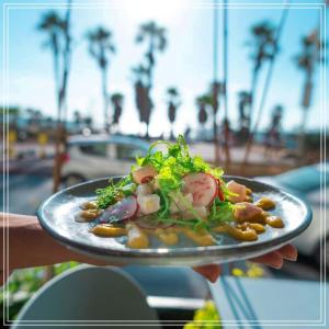 una persona tiene in mano un piatto di cibo di Bugrashov Beach 88 Hotel And Spa a Tel Aviv