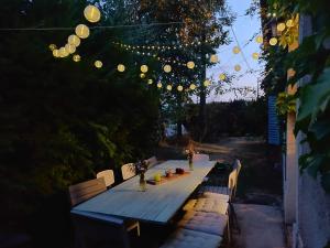 una mesa de madera con sillas y luces. en 'Maison des artistes' for up to 20 in Nature Park, en Plancher-Bas