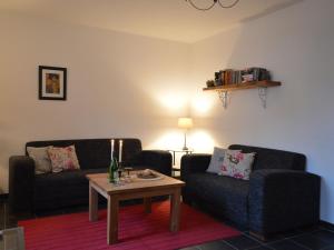 a living room with two couches and a coffee table at A modern holiday home by the River Mosel in Moselkern