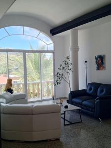 ein Wohnzimmer mit einem Sofa und einem großen Fenster in der Unterkunft Amplia habitación con balcón in Tegucigalpa