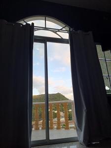 an open window with a view of a balcony at Amplia habitación con balcón in Tegucigalpa