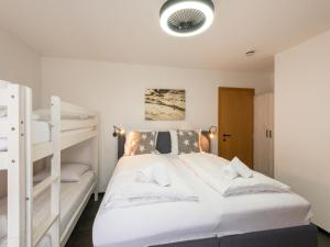 um quarto com uma cama branca e beliches em Exclusive ski-in & ski-out apartment in Ellmau em Ellmau