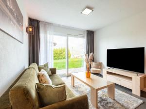 een woonkamer met een bank en een flatscreen-tv bij Exclusive ski-in & ski-out apartment in Ellmau in Ellmau