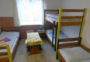 a room with two bunk beds and a table at U Dvou rysů in Zdíkov