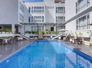 a swimming pool in front of a building at Okean De Goa Vagator in Vagator