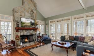 una sala de estar con una gran chimenea de piedra. en Mountain Acres Retreat - Relax by the wood fireplace and more en Jasper