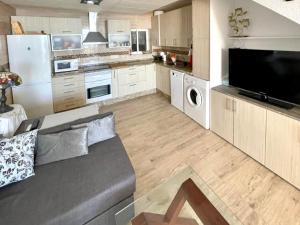 a large kitchen with a couch in the middle at Seafront apartment in La Garrofa near the beach in La Garrofa