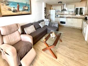 Seafront apartment in La Garrofa near the beach في La Garrofa: غرفة معيشة مع أريكة وطاولة