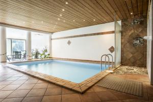 a swimming pool in a building with a tile floor at Villa Valluga in Mittelberg