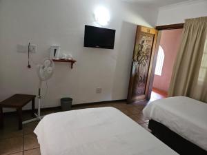 Postel nebo postele na pokoji v ubytování Rustenburg Palm Lodge