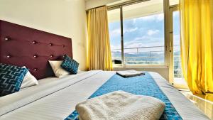1 dormitorio con 1 cama grande y ventana grande en Elenji Vitara Resort Munnar en Munnar