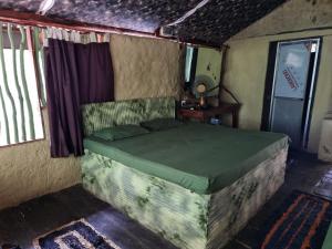 1 dormitorio con 1 cama en una habitación en Cave N Falls Nature Resort & Water Park, en Kitulgala