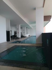a swimming pool in a building with green water at APPLE CloverLeafs Homestay Melaka in Melaka