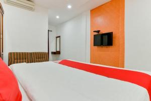 a bedroom with a bed and a tv on a wall at Malabar Plaza INN in Cochin