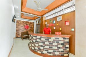 a man standing at a bar in a restaurant at Malabar Plaza INN in Cochin