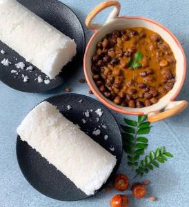 a plate of food with a cake and a bowl of beans at Malabar Plaza INN in Cochin