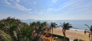 a view of a beach with palm trees and the ocean at Apec Mandala Mui Ne Beach Studio in Ấp Thiẹn Ái