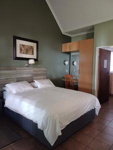 Postel nebo postele na pokoji v ubytování Rustenburg Palm Lodge