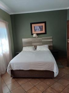 Postel nebo postele na pokoji v ubytování Rustenburg Palm Lodge