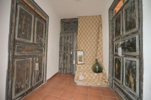 ベハルにあるVivienda Uso Turístico Alojería Béjarのタイルフロアの客室で、大きな木製ドア2つが備わります。