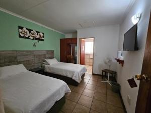 Postel nebo postele na pokoji v ubytování Rustenburg Palm Lodge