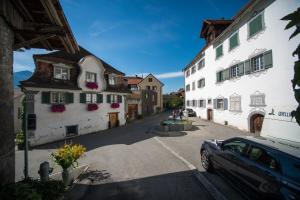 a car is parked in a street next to buildings at Haus Meierhüsli in Malans