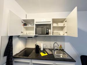 a kitchen counter with a sink and a microwave at City Spot Zimmer24Frei in Köln in Cologne