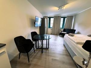 een slaapkamer met een bed en een tafel en stoelen bij City Spot Zimmer24Frei in Köln in Keulen