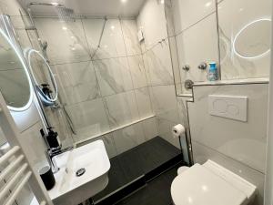 een badkamer met een douche, een toilet en een wastafel bij City Spot Zimmer24Frei in Köln in Keulen