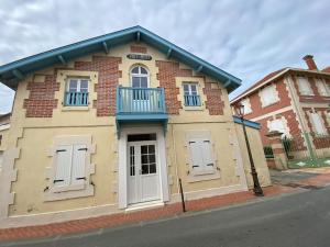um pequeno edifício de tijolos com portas brancas numa rua em Villa Soulacaise Plage et Centre em Soulac-sur-Mer