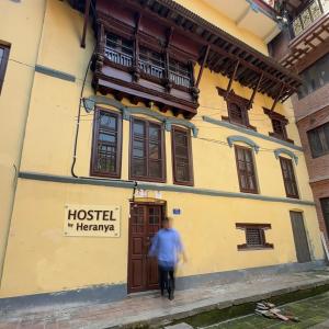 Un uomo che cammina davanti a un palazzo di Heranya Hostel a Kathmandu