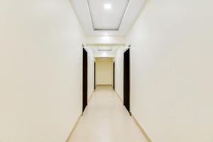 un pasillo vacío en un edificio de oficinas con paredes blancas y techo en Flagship V&s Hotel, en Pimpalgaon
