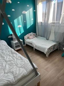 2 camas en una habitación con paredes y ventanas azules en Maison de 4 chambres avec jardin clos a Villepreux, en Villepreux