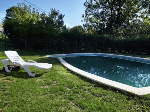 a chair and a chair next to a swimming pool at Belvilla by OYO Cottage in Nava with Swimming Pool in Nava