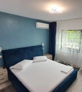um quarto com uma cama grande e uma parede azul em Apartament lângă Port Turistic Mangalia 2 camere decomandate, renovat 2023 em Mangalia