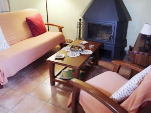 - un salon avec un canapé et une table avec une cheminée dans l'établissement 17th century farmhouse in Bages near Montserrat, à Castellfullit del Boix