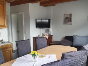 a living room with a table and a tv at Large detached holiday home in Hesse with private garden and terrace in Homberg