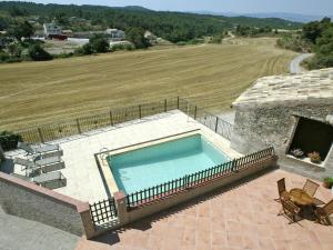 a swimming pool on top of a house with a field at 17th century farmhouse in Bages near Montserrat in Castellfullit del Boix