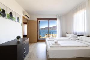 a bedroom with two beds and a view of the ocean at Residence La Corte Danese in Torri del Benaco