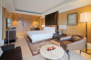 Habitación de hotel con cama y sofá en JW Marriott Mussoorie Walnut Grove Resort & Spa, en Mussoorie
