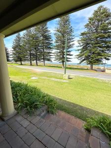 a porch with a view of a park with trees at Ardgreian in Safety Bay