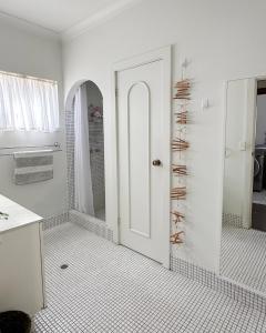 a bathroom with a shower and a white door at Ardgreian in Safety Bay