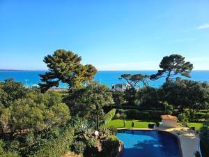 - une vue sur la piscine et l'océan en arrière-plan dans l'établissement Luxotel Cannes, à Cannes
