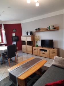 ein Wohnzimmer mit einem Sofa, einem TV und einem Tisch in der Unterkunft Ferienwohnung Mause in Medebach